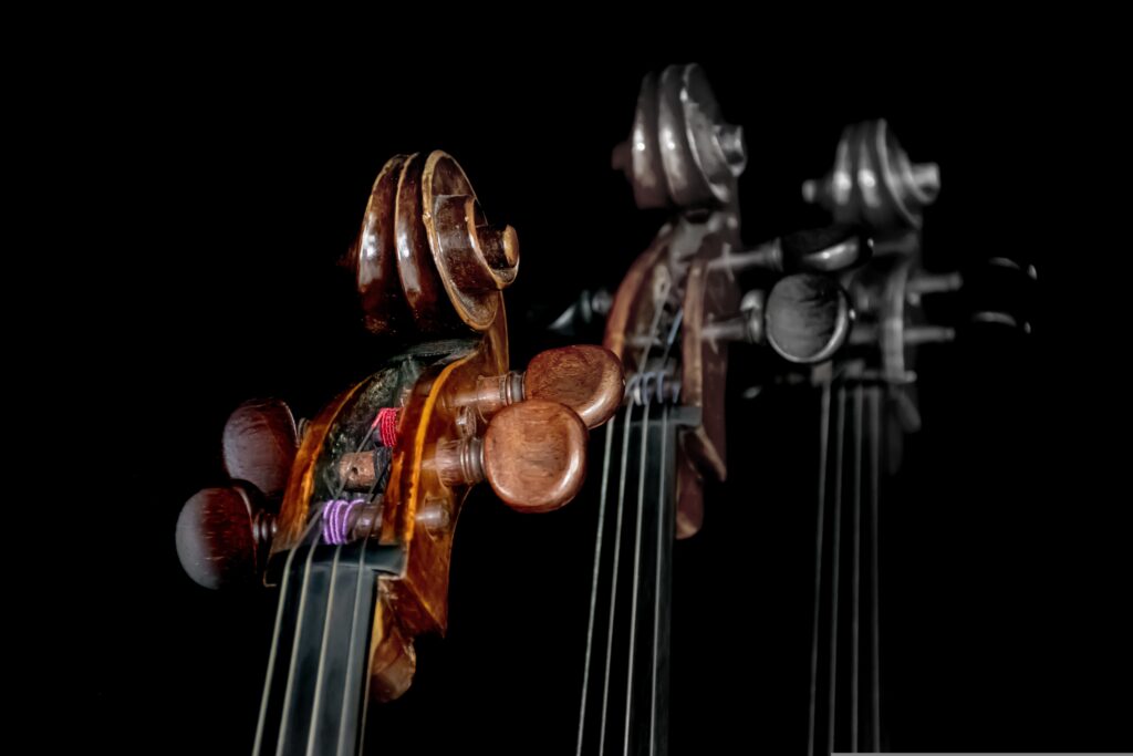 Tre bildexemplar av celloöverdel med snäcka, stämskruvar etc. Svart bakgrund. De två kopiorna gradvis suddigare, färglösare.